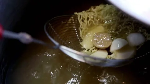 Cook the noodles while stirring and placing them in a stainless steel bowl Stock Footage 272297674