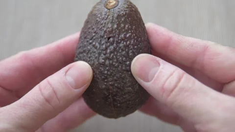The cook opens an avocado and finds that it is rotten Stock Footage 168674296
