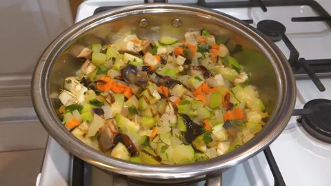 Cook opens lid of the pan, adds sauce to vegetable stew. Vegetable ragout Stock Footage 318961087