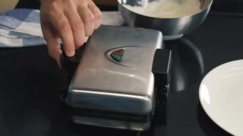 Cook opens waffle iron, takes out two fresh, hot, freshly baked Belgian waffles Stock Footage 123353582