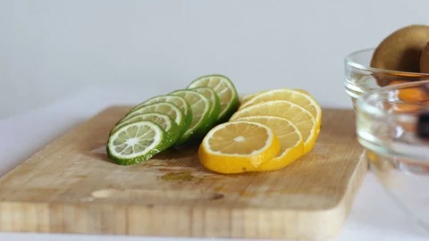 Cook or bartender preparing limes and lemons over wooden board in kitchen. Video stock 70964083