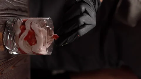 Cook, pastry chef in restaurant kitchen cooking, finishing a sweet strawberry Stock Footage 249454330