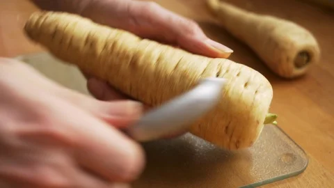 Cook peeling a parsnip root Stock Footage 71485295