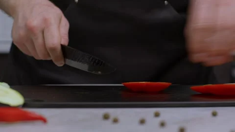 The cook peels a large red bell pepper with a sharp knife, strong male hands Видео 269894970