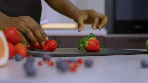 A cook peels strawberries on the kitchen table, a chef cuts strawberries on a Видео 269894192