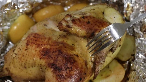 Cook pierces the roasted or fried chicken or turkey with a fork. Stock Footage 121330878