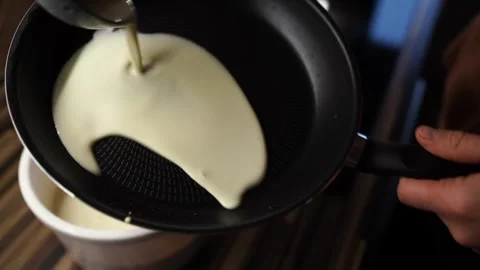 Cook pours the batter into the pan and puts the pancake to bake Video stock 274306820