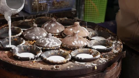 A cook pours batter into round molds while preparing traditional ban can food on Stock Footage 338001036
