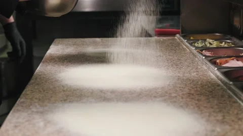 The cook pours cornflour onto the table. the process of making pizza in Stock Footage 232381663