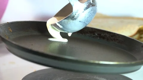 The cook pours the dough to make a pancake in a frying pan Stock Footage 85951537