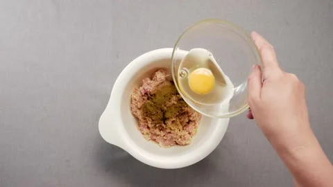 Cook pours egg into minced meat Stock-Footage 161896283