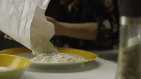 The cook pours flour into a plate from a pack. Slow motion Stock Footage 263962992