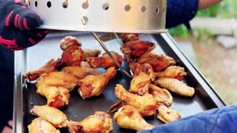 Cook Pours Fried Chicken Wings Onto Metal Tray Stock Footage 346649053