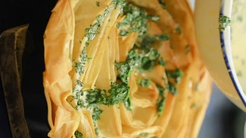 The cook pours a mixture over the banitsa. Vertical video. Stock Footage 305154559