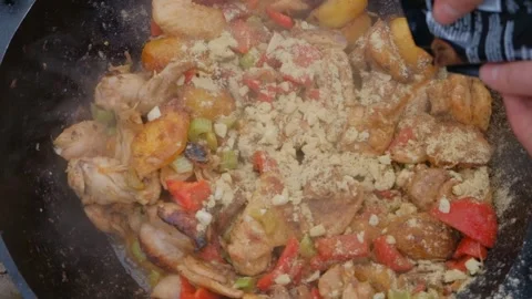 The cook pours spices into the dish. Adding spices when cooking. Spices are Stock Footage 278926187