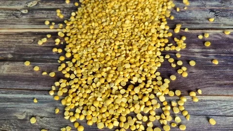 The cook pours split peas on a wooden table Stock Footage 230015038
