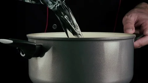 The cook pours water into the pan Stock-Footage 76018321