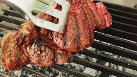 Cook prepares beef steaks on grill Stock-Footage 157136352