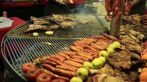 Cook prepares chicken legs on an open fire in a medieval market Vídeo Stock 61293554