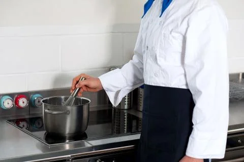 A cook prepares a dish in the kitchen Stock Photos