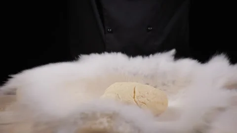 The cook prepares dough on a work surface, rolling it with a rolling pin Stock Footage 278454865