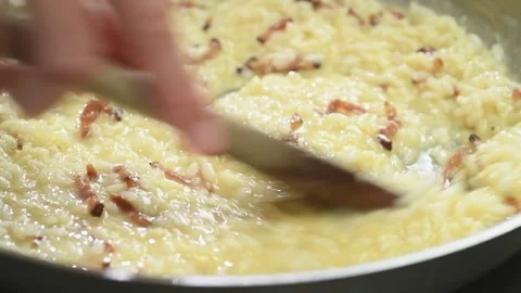 The cook prepares risotto alla carbonara in a frying pan. Stock Footage 170903373