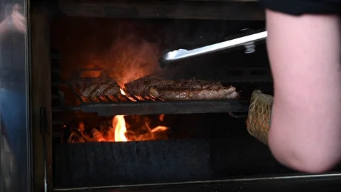 The cook prepares steaks on the grill Stock Footage 125889804