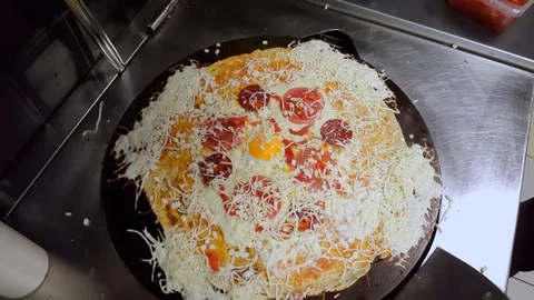 Cook preparing a crepe with cheese, Turkish sauge (sucuk) and egg Stock Footage 103875702