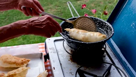Cook preparing fried dumplings in a pan full of seed oil. Stock Footage 135900952