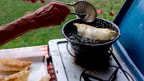 Cook preparing fried dumplings in a pan full of seed oil. Stock Footage 135901033