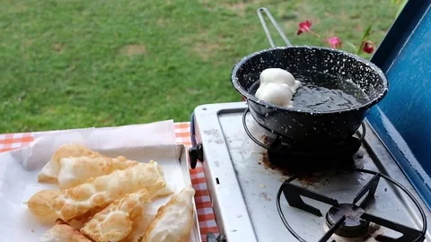 Cook preparing fried dumplings in a pan full of seed oil. Stock Footage 135901113