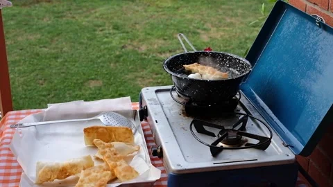 Cook preparing fried dumplings in a pan full of seed oil. Stock Footage 135901275