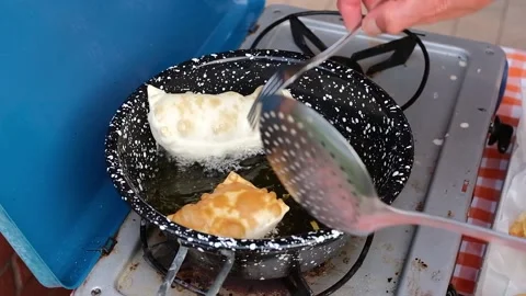Cook preparing fried dumplings in a pan full of seed oil. Stock Footage 135901343