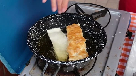 Cook preparing fried dumplings in a pan full of seed oil. Stock Footage 135901344