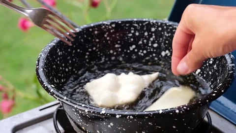 Cook preparing fried dumplings in a pan full of seed oil. Stock Footage 135901525
