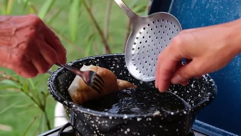 Cook preparing fried dumplings in a pan full of seed oil. Stock Footage 135901557