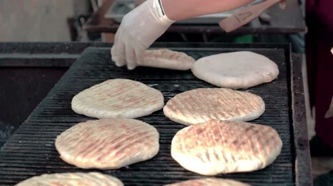 Cook preparing pieces of homemade bread on grill. Street food festival. Stock Footage 51172653
