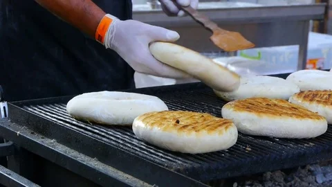 Cook preparing pieces of homemade bread on grill. Street food Stock Footage 84253458