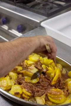 Cook preparing poor potatoes, typical of Spain with potatoes and onions. Stock Photos