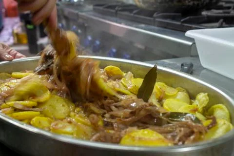 Cook preparing poor potatoes, typical of Spain with potatoes and onions. Stock Photos