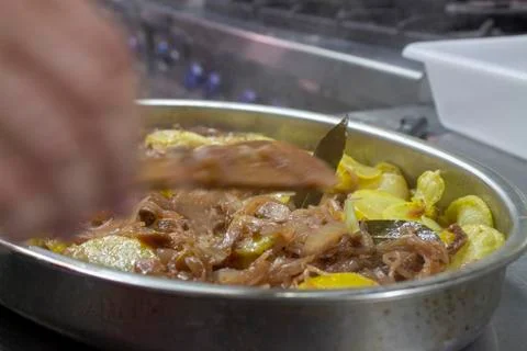 Cook preparing poor potatoes, typical of Spain with potatoes and onions. Stock Photos