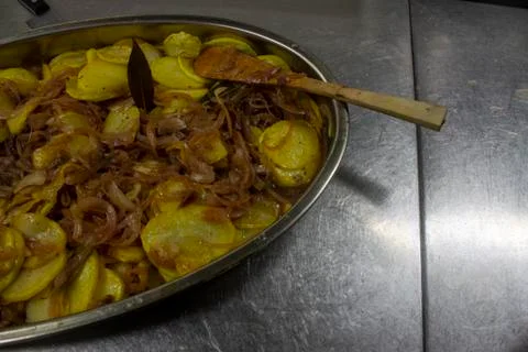 Cook preparing poor potatoes, typical of Spain with potatoes and onions. Stock Photos