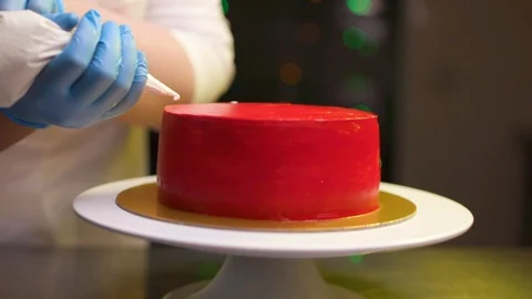 A cook is preparing a red cake for Christmas and New Year. Stock Footage 119856802