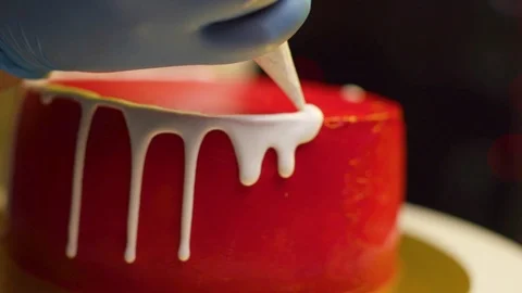 A cook is preparing a red cake for Christmas and New Year. Stock Footage 119856814