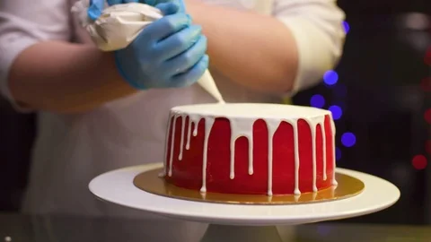 A cook is preparing a red cake for Christmas and New Year. Stock Footage 119856833