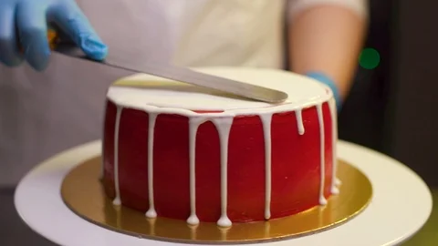 A cook is preparing a red cake for Christmas and New Year. Stock Footage 119856835