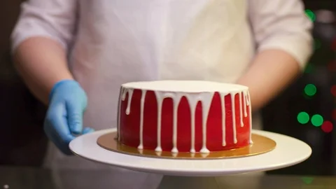 A cook is preparing a red cake for Christmas and New Year. Stock Footage 119856844
