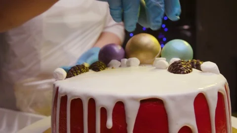 A cook is preparing a red cake for Christmas and New Year. Stock Footage 119856848