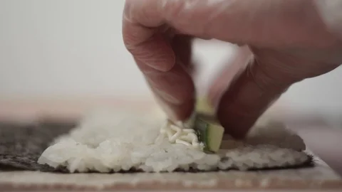 Cook preparing rolls. Puts cucumber and smoked chicken as a filling Stock Footage 106670339