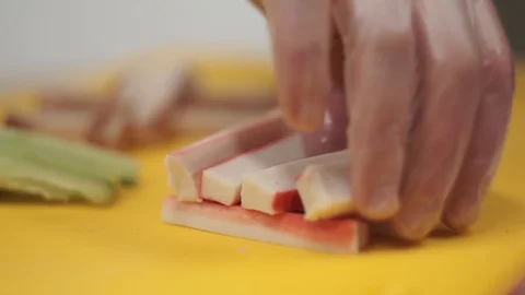 Cook preparing rolls. Takes crab sticks off the table Video stock 106670664